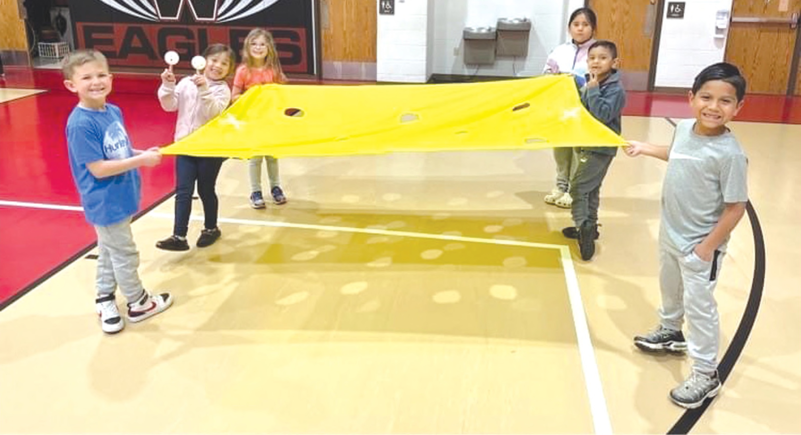 Students in Shaylee Seright’s first-grade class work on team building skills during PE class.