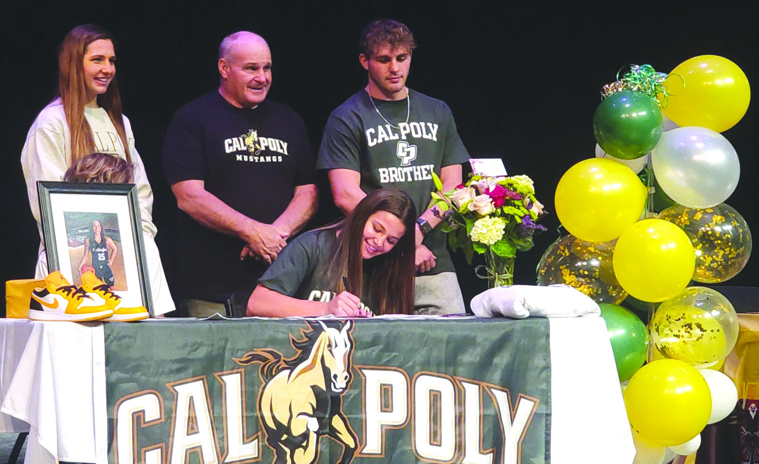 Jordan Hoffman, front and sitting, signs her letter of intent to play basketball for the Cal Poly Mustangs. She is pictured with sister Addy, left, father Scott and brother Tyler Jack. Ashley Adams/WDN