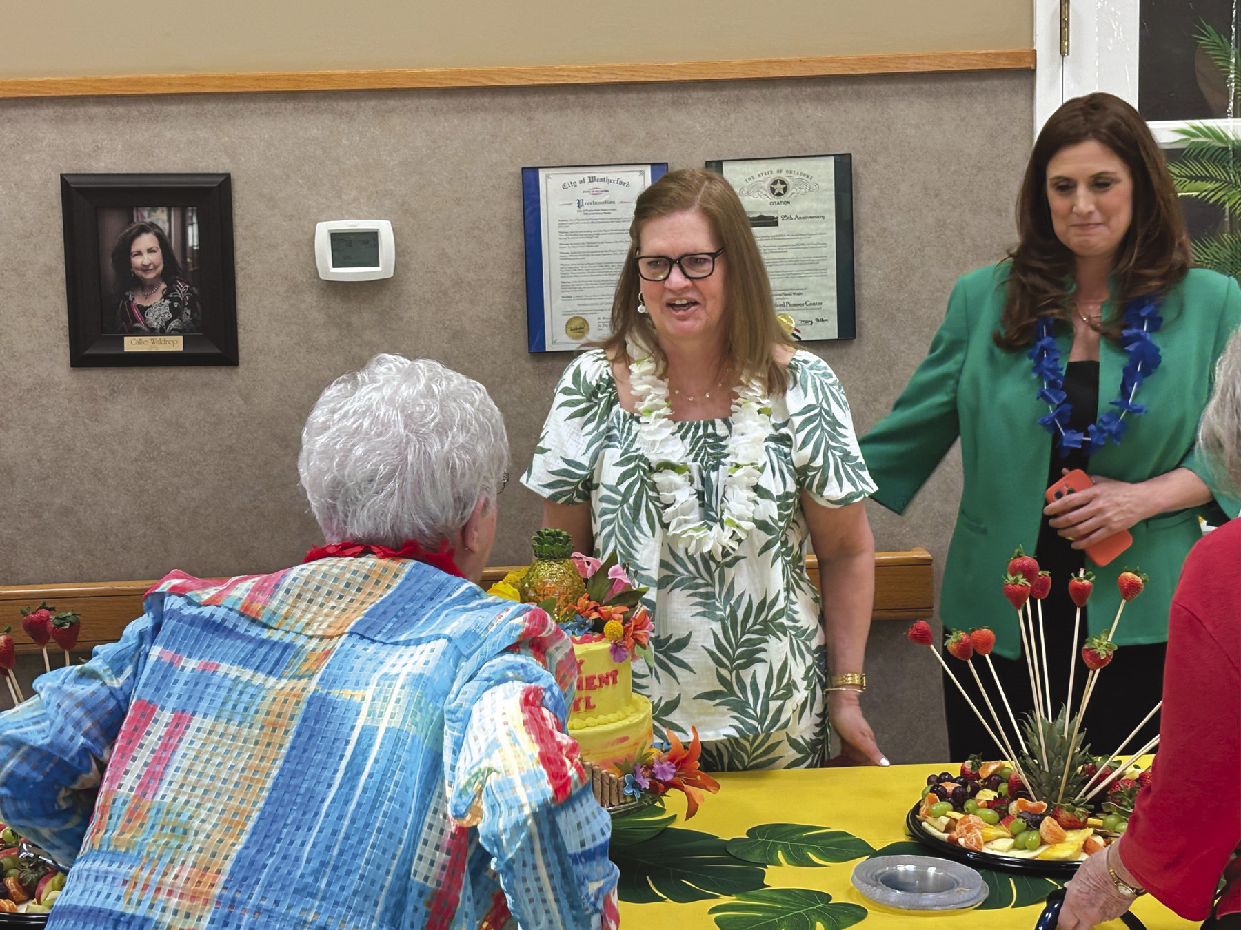 The Pioneer Center honors Cheryl Burleigh, standing behind the table in white, on her retirement Friday. Sarah Cook/WDN