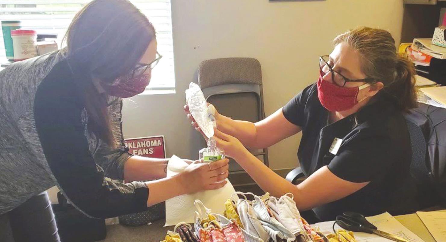 Staff members at an eastern Oklahoma nursing home refill bottles of hand sanitizer. Provided