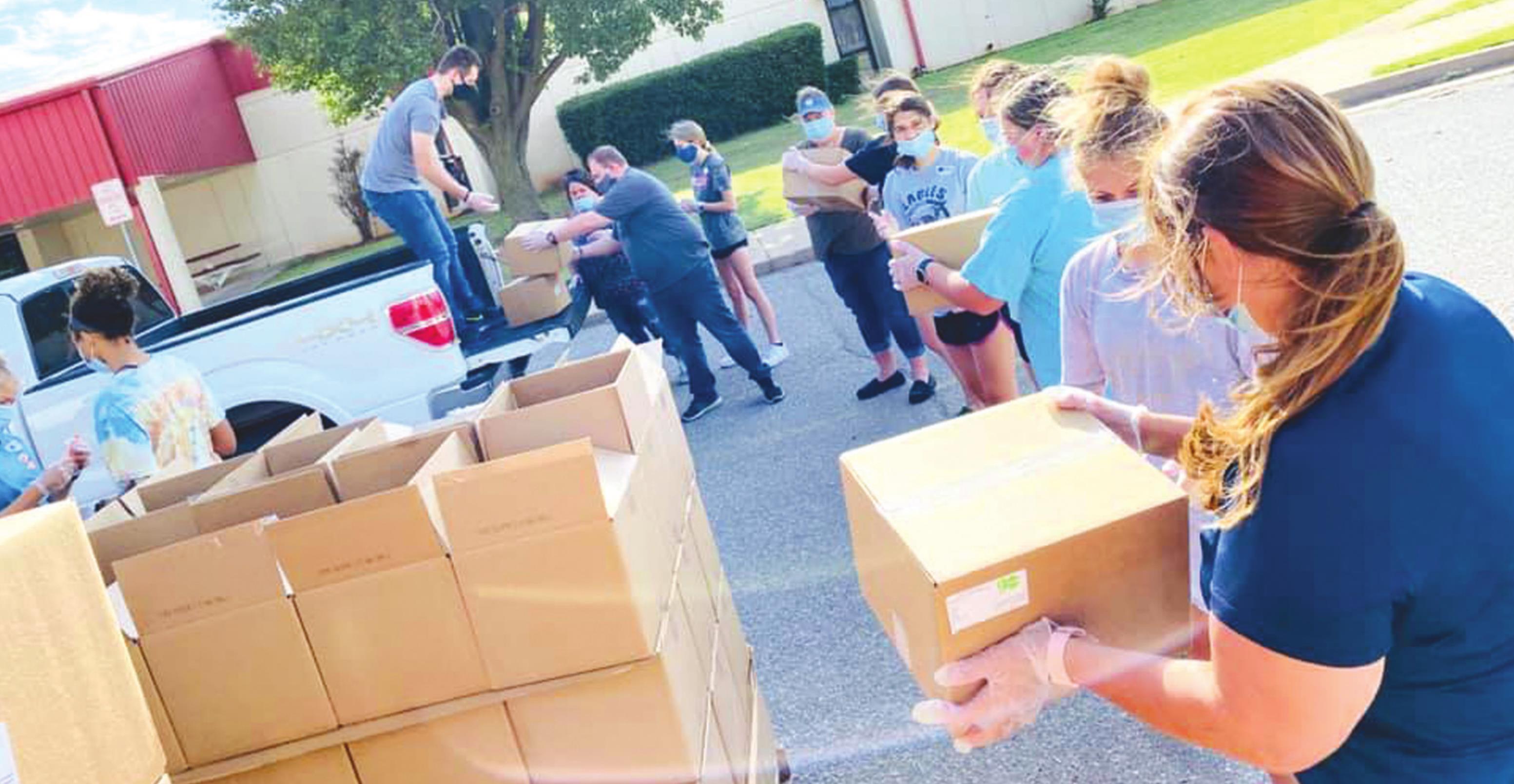 Volunteers load boxes for the Pioneer Center during a food box pick-up at Weatherford High School. Phillip Reid/WDN