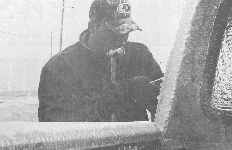 SWOSU student Bryan Harrison chisels the ice from his pickup after the ice storm in 2002. The Jefferson Hall resident advisor encouraged his residents to go home until the power was restored. Photo from February 1, 2002