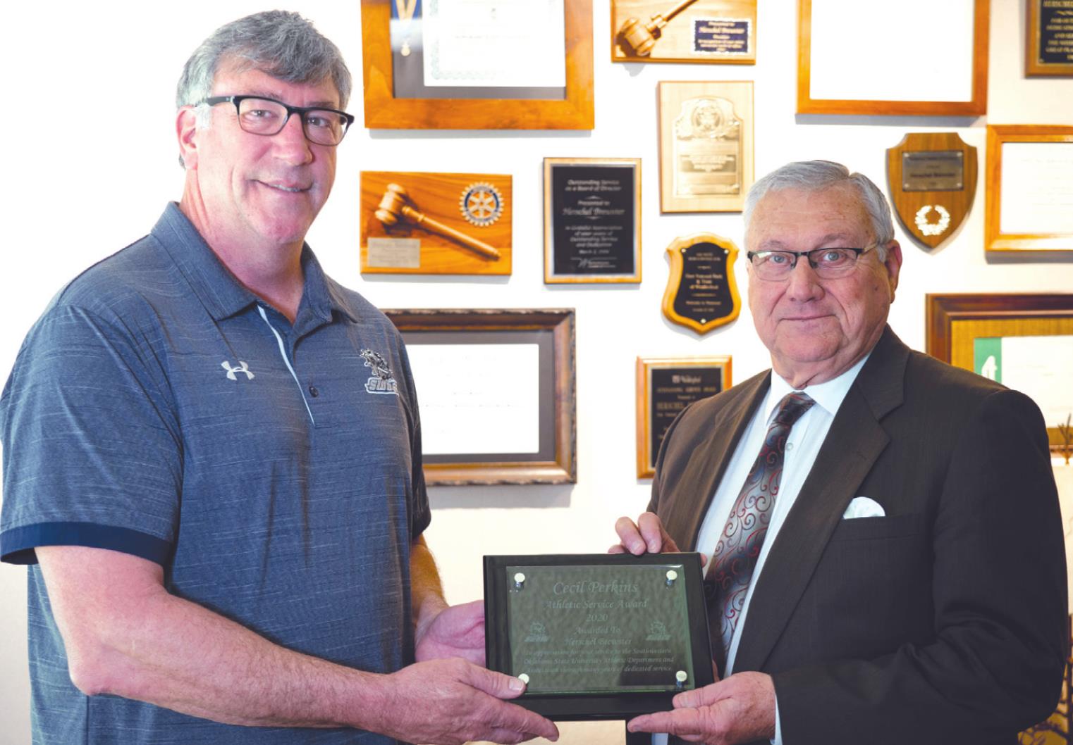 SWOSU Athletic Director Todd Thurman, left, present the Cecil Perkins Service Award to First National Bank and Trust Co. President and CEO Herschel Brewster. Provided