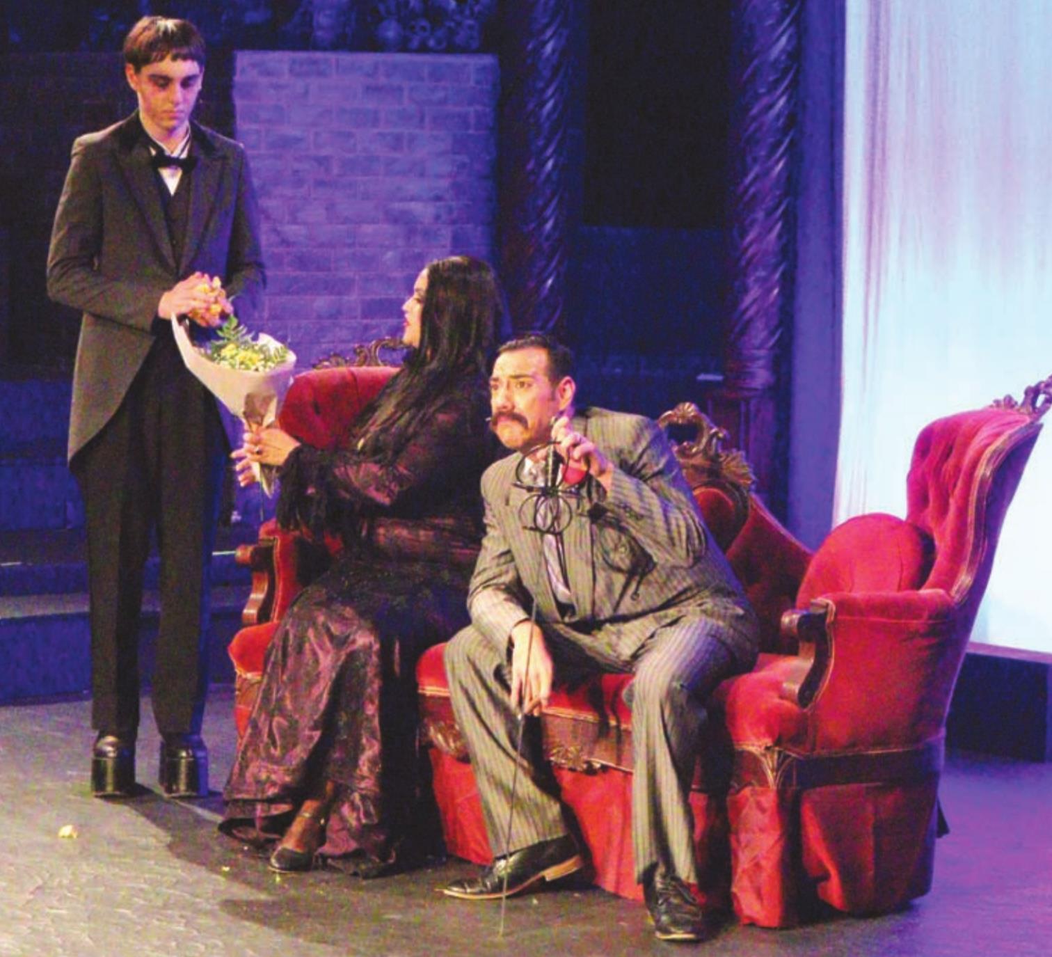 Morticia and Gomez Addams, played by Blair Barnett Foley and Oscar Hernandez, examine a bouquet of the dreadfully cheerful flowers. Also pictured is the Addams’ butler, Lurch, played by Gavin Houck. Leanna Cook/WDN