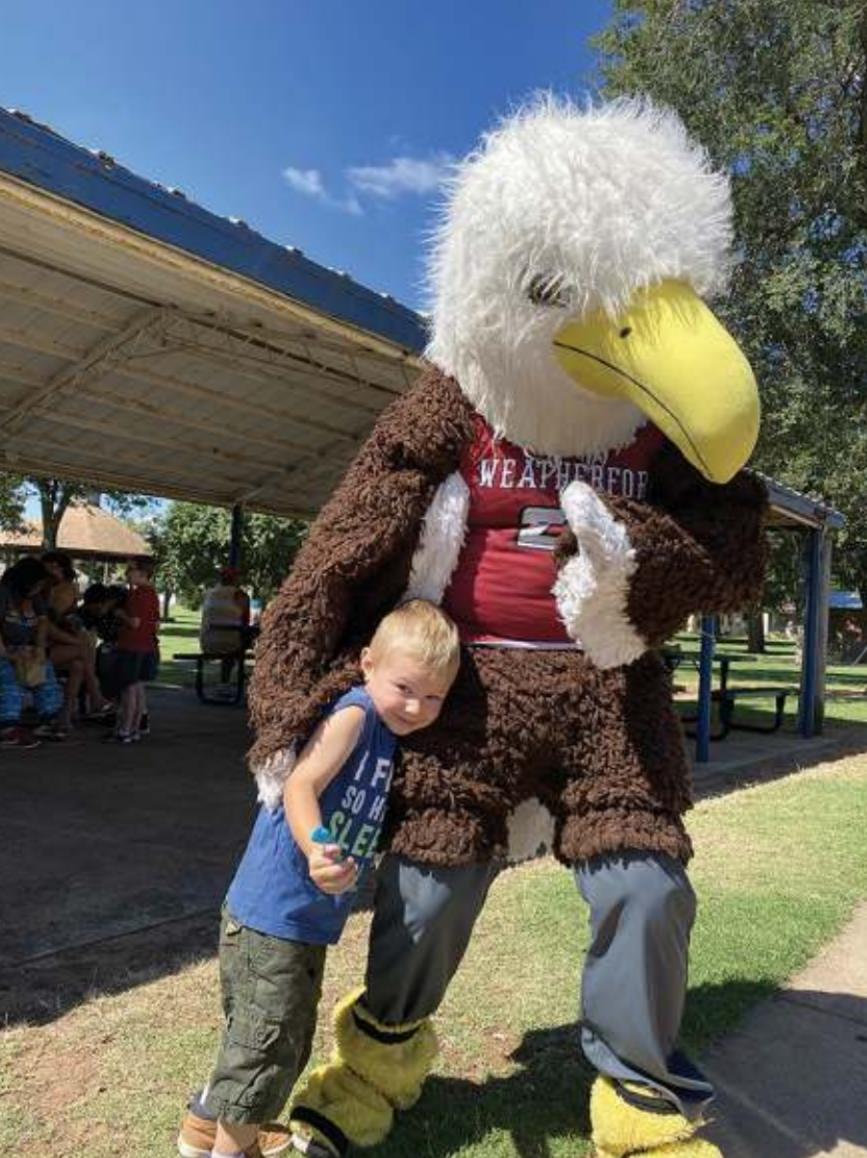 Weatherford’s eagle mascot welcomes a student during Picnic in the Park, a summer outreach program to provide sack lunches to students and families in need. File photo