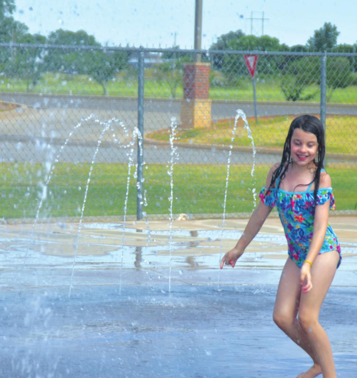 Prezley Wright is splashing into summer as she plays at the splash pad near Rader Park. Josh Jennings/WDN