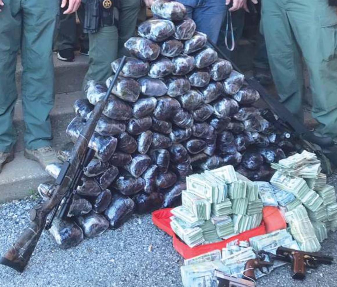 Pictured left is the cache of weapons, currency and methamphetamine siezed by the Oklahoma Bureau of Narcotics with the help of the Grove Police Department. Provided