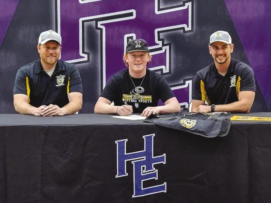 Hydro-Eakly Senior Korbin Smith, center, signs a letter of intent with the Fort Hays State University shooting sports team